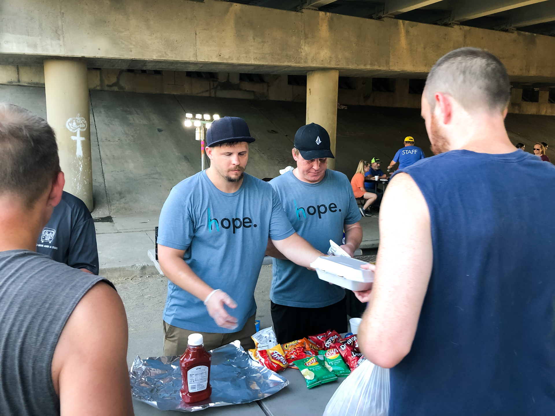 A man from the Sangha community volunteering at a community event and passing out food.